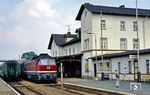 132 100 (Bw Eisenach) ist mit dem im Bahnhof Gerstungen endenden P 7063 aus Eisenach angekommen. Das damals noch durch die DR genutzte Bahnhofsgebäude ist seit Juli 2012 im Besitz eines Gastronomiebetriebes. Die ehemalige Mitropa wird als Festsaal genutzt.  (26.07.1990) <i>Foto: Wolfgang Bügel</i>