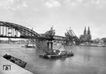 Ersatz des provisorischen SKR-Stahlüberbau über der mittleren Stromöffnung der Hohenzollernbrücke zwischen Köln Hbf und -Deutz. Im freien Vorbau wird der neue Bogen errichtet. (1952) <i>Foto: Fischer</i>