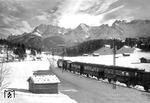 Fahrt auf der Mittenwaldbahn ins Karwendelgebirge: Ein Wintersportzug, geführt von einer BBÖ 1070, ist mit einer bunten Wagengarnitur bei Klais nach Garmisch-Partenkirchen unterwegs.  (1936) <i>Foto: RVM (Huber)</i>