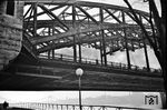 Ein Blick auf die Brückenunterkonstruktion der Hohenzollernbrücke in Stahlbauweise. Die Bauausführung erfolgte von 1907 bis 1911 unter maßgeblicher Beteiligung des MAN-Werks Gustavsburg. Im Hintergrund ist schemenhaft die alte Deutzer Hängebrücke zu erkennen, die 1945 in den Rhein stürzte. (1938) <i>Foto: Theo Felten</i>
