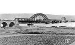 Der Bau der "Hindenburgbrücke" bei Rüdesheim (Rhein) erfolgte aus militärstrategischen Erwägungen zwischen 1913 und 1915. Sie war Teil einer "Brückenfamilie" aus drei ähnlichen Eisenbahnbrücken über den Rhein, die beiden anderen waren die "Kronprinzenbrücke" bei Urmitz und die "Ludendorffbrücke" bei Remagen. Der zivile Verkehr war allerdings so gering, dass die Reichsbahn zwischen die Gleise eine Fahrbahn für Kraftfahrzeuge verlegen ließ, die die Brücke zum Preis von 4 RM überqueren durften. Lediglich bei den seltenen Zugfahrten wurde sie für den Kraftfahrzeugverkehr gesperrt. Ab 13.01.1945 war die Brücke wegen Luftangriffsschäden unbefahrbar, wurde nicht repariert und am 15.03.1945 durch deutsche Pioniere gesprengt. Nach dem Krieg wurde sie nicht wieder aufgebaut.  (1930) <i>Foto: RVM</i>