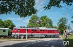142 001 der Erfurter Bahnservice Gesellschaft überquert mit einem Personenzug nach Bergen auf Rügen die Fürst-Malte-Allee am Bahnhof Lauterbach. (26.05.2024) <i>Foto: Joachim Schmidt</i>