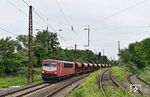 155 078 der Budamar West GmbH Saalburg-Ebersdorf überführt leere Schotterwagen von Cottbus nach Marburg (Lahn). Im Abschnitt Leipzig-Schönefeld nach Leipzig-Thekla wird im Sommer 2024 die Oberleitung erneuert. Dabei werden auch die Masten für die Quertragwerke aus den 1950er Jahren erneuert. Links sehen wir ein neu gegossenes Fundament. Rechts sieht man das Ausziehgleis von Schönefeld, das für die Bedienung des nach rechts abzweigenden Industrieanschlusses genutzt wird.  (03.06.2024) <i>Foto: Ralf Opalka</i>