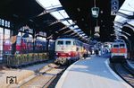 In Köln Hbf ist 103 230 mit IC 645 "Bergisches Land" aus Aachen eingefahren. Auf der Lok findet gerade ein Personalwechsel statt. Daneben steht 111 154 vor einer S 11 nach Bergisch-Gladbach, links 215 048 aus der Eifel. (02.04.1990) <i>Foto: Joachim Bügel</i>