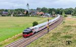 218 497 brummt mit IC 2074 nach Westerland (Sylt) durch Risum-Lindholm. Die Lok hebt sich durch ihre auffällige Lackierung ab. Sie ist das Ergebnis eines Kreativwettbewerbs unter den Mitarbeitern des Fahrzeuginstandhaltungswerks Cottbus und symbolisiert die Geschichte des Werkes von der Dampflokzeit (schwarz) bis zur ICE-Zeit in grau mit rotem Band. (04.08.2024) <i>Foto: Joachim Schmidt</i>