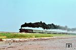 012 101 mit dem D 820 aus Hamburg-Altona am Ende des Hindenburgdamms kurz vor Morsum. Das berüchtigte Rohreblasen wurde sonst eigentlich erst in der Gegenrichtung vollführt. Dabei wurde eine Schaufel Sand in die Feuerkiste geworfen, Bläser auf voll und sofort quoll rabenschwarzer Qualm aus dem Schornstein. Das - offiziell verbotene und inoffiziell geduldete - Rohreblasen diente dazu, das an den Innenseiten der Rauch- und Heizrohre und an den Außenseiten der Überhitzerelemente "klebende" unverbrannte Öl zu beseitigen. (21.08.1971) <i>Foto: Helmut Dahlhaus</i>