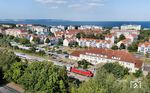 101 102 ist mit IC 2268 aus Hamburg im Zielbahnhof Ostseebad Binz eingetroffen. In der Ferne sind der Fährhafen Mukran (links), Sassnitz und die Kreidefelsen auszumachen. (26.08.2024) <i>Foto: Joachim Schmidt</i>