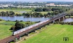 Die Weserbrücke bei Dreye wurde als Teil der Hamburg-Venloer Bahn von der Köln-Mindener Eisenbahn-Gesellschaft erbaut und ging am 15. Mai 1873 in Betrieb. Das Bauwerk besteht aus zwei Abschnitten. Die 184 Meter lange Strombrücke überspannt die Weser mit drei gleich langen stählernen Überbauten. Die Weser bildet hier die Grenze zwischen den Bundesländern Bremen und Niedersachsen. Die im Westen anschließende Flutbrücke über dem Vorlandbereich ist 423 Meter lang und wird gerade vom IC 2201 (Bremerhaven-Lehe - Köln Hbf) befahren. (02.08.2024) <i>Foto: Joachim Schmidt</i>