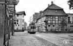 Durch die Mühlenenge in Schloß Neuhaus zwängte sich sowohl die Straßenbahnlinie 1 der PESAG als auch – bis zum Bau der Neuhäuser Umgehungsstraße – die Bundesstraße B 68. Hier ist der Tw 36 mit Bw 86 in Richtung Sennelager unterwegs. Die Brautradition des Paderborner Bieres, das links in der Kneipe angeboten wird, geht bis ins Jahr 1852 zurück. Die Paderborner Brauerei existiert - im  Gegensatz zur Straßenbahn - heute noch, gehört allerdings seit 1990 zur Warsteiner-Gruppe. (12.07.1960) <i>Foto: Aad van Ooy</i>