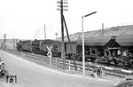 39 116 und eine 50er passieren mit einem Güterzug nach Limburg (Lahn) den Bahnübergang der Bundesstraße 8 in Niederbrechen. (03.1964) <i>Foto: Karl-Ernst Maedel</i>