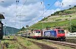 Die erste Tour des Offenbacher Krankenhauses bespannte 111 213 von smart-rail, die hier mit ihrer Garnitur im Bahnhof Rüdesheim von SBB 482 030 mit DGS 43741 (Köln-Eifeltor - Novara/It) überholt wird. (12.06.2024) <i>Foto: Marvin Christ</i>