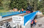 Die zweiteilige Brücke über das Schwarzwasser in der Einfahrt zum Bahnhof Schlössel wurde seit 2005 durch eine zusätzliche Stützkonstruktion sowie durch Einschränkungen der Geschwindigkeit und intensiven regelmäßigen Inspektionen in einem betriebsfähigen Zustand erhalten. Die Materialermüdungen an dem 1892 eingebauten Längsträgerüberbau sowie dem nach einem Hochwasser 1955 eingebauten vormaligen regelspurigem Brückensegment waren jedoch soweit fortgeschritten, dass nur noch eine zeitnahe Erneuerung der Brücke übrig blieb. Nach einer Bauzeit von nur vier Monaten konnte am 30.09.2024 die neue Brücke eröffnet werden. Die Belastungsprobe absolvierte 99 1715. (30.09.2024) <i>Foto: Joachim Schmidt</i>