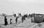 Lebhafte Verabschiedung der Feriengäste am Deichdurchlass kurz hinter dem Bahnhof Wangerooge. Im Hintergrund ist der alte Leuchtturm aus dem Jahr 1856 zu sehen, der bis 09. Dezember 1969 in Betrieb war.  (08.1966) <i>Foto: Jürgen Munzar</i>