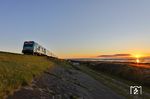 Sonnenaufgang am Hindenburgdamm: 245 215 schiebt den  RE 11013 nach Hamburg-Altona zum Festland. (03.10.2024) <i>Foto: Joachim Bügel</i>