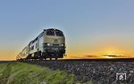 Als 218 330 mit RE 11052 nach Westerland (Sylt) auf dem Hindenburgdamm erschien, versteckte sich die aufgehende Sonne nochmals kurz. (03.10.2024) <i>Foto: Joachim Bügel</i>