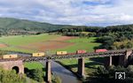 Ein Containerzug mit einer 185 fährt über die Werrabrücke Oberrieden südwärts. Bis 1945 verlief die alte Grenzlinie zwischen Hessen und Thüringen auf der Straße im Tal. Die Nord-Süd-Strecke wurde nach dem Krieg zu einer der wichtigsten Nachschubwege der amerikanischen Truppen zum Seehafen Bremerhaven. Südlich von Eichenberg führte die Strecke kurz über thüringisches Gebiet, das zur sowjetischen Besatzungszone gehörte. Durch einen Gebietstausch lag die gesamte Nord-Süd-Strecke schließlich komplett westlich der innerdeutschen Grenze. (27.09.2024) <i>Foto: Joachim Schmidt</i>