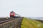 218 406 erhielt am 13.09.2023 im Rahmen einer IS 930 im Werk Bremen eine orientrote Retrolackierung. Zur Freude des Fotografen tauchte die Kemptener Lok Anfang Oktober 2024 auf der Marschbahn auf. Leider wurde die Freude etwas getrübt, da es die DB fast nie schaffte, die planmäßige Leistung der Lok vor dem IC 2214 aus Köln halbwegs pünktlich nach Sylt zu bringen und der Zug des öfteren in Hamburg-Dammtor oder Niebüll endete. So blieben nur ein paar Schlechtwetterbilder übrig, wie hier auf dem Hindenburgdamm östlich von Morsum. (07.10.2024) <i>Foto: Joachim Bügel</i>