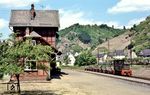 V 18 vor einem mit Rohblei-Blöcken beladenen Güterzug vor dem Bahnhofsgebäude der Nassauischen Kleinbahn in Braubach. Das Gebäude musste nach Stilllegung der Bahn einer Rettungswache weichen. (22.05.1972) <i>Foto: Wolfgang Jahn</i>