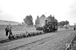 99 253 rangiert an der Rollbockgrube des Bahnhofs Regensburg Kalkwerke die Rollböcke zusammen. Durch den Einsatz von Rollböcken konnte im Güterverkehr der Schmalspurbahn das Umladen der Güter von den Normalspurfahrzeugen in die Schmalspurwagen entfallen. Auf dem Rollbock wurden die Räder jeweils eines Radsatzes des Normalspurwagens verankert. Für einen zweiachsigen Güterwagen waren also immer zwei Rollböcke erforderlich. Die Beförderung vierachsiger Güterwagen auf Rollböcken war nicht möglich. Normalspurwagen auf Rollböcken wurden mittels Kuppelstangen verbunden. Die Verbindung mit dem Zugfahrzeug erfolgte ebenfalls über Kuppelstangen. (06.1957) <i>Foto: Gerhard Karl</i>