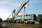 Der Lokkasten der Unfalllok 140 637 wird in Münster-Nevinghoff mittels des 150 t-Krans "Goliath" auf ihre Drehgestelle verladen. Die Lok wurde zunächst ins AW Bremen verfrachtet. Später im AW Opladen wieder ausgebessert, verließ sie die Werkstatt im Frühjahr 1980 in ozeanblau/beiger Farblackierung. (30.09.1979) <i>Foto: Bernd Kappel</i>