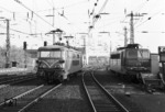 Die Serie 26 der SNCB wurde in der zweiten Hälfte der 1960er Jahre gebaut und orientierte sich an der französischen BB 9400. Lok 2635 war die letzte Lok der Bauserie und spannt hier an der Ostseite des Aachener Hauptbahnhofs vom Zug ab. Für die restliche Strecke nach Köln wird die Köln-Deutzerfelder Mehrfrequenzlok 184 111 (rechts) den Zug übernehmen. Aachen Hbf besitzt als Besonderheit eine doppelte Fahrdrahtführung, die wechselweise mit dem deutschen 15 kV 16,7 Hz Wechselstromnetz oder dem belgischen 3 kV Gleichstrom betrieben werden kann. (21.11.1976) <i>Foto: Udo Kandler</i>