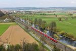 Der Aufstieg zum Plentl-Kreuz südlich von Nabburg ist zwar etwas mühselig, eröffnet aber diesen schönen Ausblick auf das Naabtal. 218 403 ist mit RE 4865 nach München unterwegs. (14.04.2025) <i>Foto: Joachim Bügel</i>