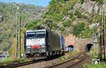 Auf der Rechten Rheinstrecke entstand zwischen 1859 und 1861 der 368 Meter lange Loreley-Tunnel südlich von St. Goarshausen. Das alte Tunnelportal steht heute unter Denkmalschutz, nicht zuletzt wegen seines burgenähnlichen Stils. 100 Jahre nach dem Bau des ersten Loreley-Tunnels entstand parallel ein neuer Tunnel. Dieser wurde notwendig, weil im Zuge der Streckenelektrifizierung eine temporäre Stilllegung des alten Tunnels eine nicht zu kompensierende Einschränkung im Bahnbetrieb gewesen wäre. Nach Inbetriebnahme der zweiten Tunnelröhe wurde die Strecke dann jeweils eingleisig durch die Tunnel geführt. MRCE-Dispolok ES 64 F 4-090 (189 990) verlässt mit einem südwärts fahrenden Güterzug das alte Tunnelportal des Loreley-Tunnels. (12.04.2025) <i>Foto: Joachim Schmidt</i>