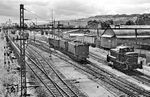 E 320 20 fährt mit einer unbekannten Schwesterlok vor einem kurzen Nahgüterzug aus dem Bahnhof Lörrach. Rechts steht V 60 370 aus Haltingen. (07.1958) <i>Foto: Jürgen Hagemann, Slg. R. Garn</i>