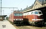 Am Ostersonntag des Jahres 1983 überholt 250 071 vom Bw Leipzig Wahren mit ihrem Güterzug am menschenleeren Bahnsteig 6 des Erfurter Hbf die Jüterboger 118 698. Die seinerzeit moderne E-Lok wurde bereits am 21.07.2005 ausgemustert. (20.04.1983) <i>Foto: Thomas Fischer</i>