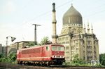 Die abweichend in orangerot lackierte Dresdener 250 224 passiert auf ihrem Weg nach Dresden Neustadt als Lz-Fahrt den imposanten Tabakkontor. Nach dem Krieg war hier ab 1953 der VEB Tabakkontor untergebracht. Sämtliche Zigarettenfabriken der DDR wurden von Dresden aus mit Rohmaterial versorgt. Die Lampe im Vordergrund gehört zu einer Baustellenbeleuchtung an der dort beginnenden Marienbrücke. (23.06.1984) <i>Foto: Thomas Fischer</i>