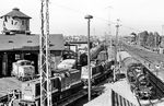74 1230 hat gemeinsam mit 106 622 mit einen Personenzug-Pendel als Zubringer aus dem Bahnhof Stralsund das Bw Stralsund erreicht. Aus heutiger Sicht ist der Blick von der Fußgängerbrücke auch ohne die 03.10 durchaus intererssant: Viele besetzte Gleis mit Lokomotiven der BR 106, 112 und 172, ein große Anzahl abgestellter Wagen und im Hintergrund ein gut ausgelasteter Güterbahnhof. Allerdings zeigt der Wasserturm einen bereits bedenklichen Zustand, der heute zu einer weiträumigen Sperrung des Areals führen würde. Er wurde wegen des drohenden Verfalls später mit einem Netz versehen. (01.10.1988) <i>Foto: Thomas Fischer</i>