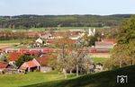 Vor der den Aposteln Peter und Paul geweihten romanischen Basilika aus dem Jahr 1120 zieht 218 416 mit RE 4867 nach München bei Haindorf vorbei. (16.04.2025) <i>Foto: Joachim Bügel</i>