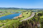 Der vierspurige Ausbau der Bundesstraße 17 hat den einstigen Fotoklassiker am Niedersonthofener See mit Mitterinselsee und Unterinselsee bei Martinszell nachhhaltig unmöglich gemacht. So bleibt für den IC 2084 mit 218 446 nur noch die Perspektive aus der Luft. (02.05.2025) <i>Foto: Joachim Schmidt</i>