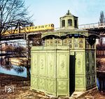 Ein A3 L-Triebwagen der Linie 2 auf der Brücke über den Landwehrkanal am Tempelhofer Ufer mit einem "Café Achteck", einem typisch Berliner Pissoir für Männer. Die scherzhafte Bezeichnung der Bedürfnisanstalten rührte von den sieben grün lackierten gusseisernen Wandsegmenten her, die einen achteckigen Grundriss bilden. Das achte Element fehlte, denn es war der Eingang, bei dem ein davor stehender Paravent einen Sichtschutz bildete. Der Entwurf stammte von einem Berliner Stadtbaurat aus dem Jahr 1878. Im Jahr 1920 gab es etwa 142 von diesen Pissoirs in Berlin. Heute existieren noch etwa 30 dieser Einrichtungen.  (1978) <i>Foto: Karsten Risch</i>