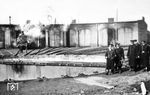 Vor dem Ringlokschuppen des Bw Gretschany wird an einer preußischen G 8¹ oder G 10 gewerkelt, während eine Inspektion durch das Bw-Gelände streift. Lokschuppen und Drehscheibe wurden 1942 von der Organisation Todt maßgeblich instandgesetzt. Der Bahnknoten Gretschany liegt an der Magistrale Lemberg—Tarnopol—Shmerinka—Odessa. Das Bahnbetriebswerk unterstand dem Maschinenamt Winniza der RVD Kiew.  (15.03.1943) <i>Foto: Dipl.-Ing. Kurt Wenzelburger</i>