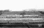 Ein Einheitstriebwagen der Reichsbahn (137 080-093) mit Essener Grundriss als E 3452 (Dortmund – Düren) bei Wuppertal-Langerfeld. Bei diesem Fahrzeuggrundriss wurden alle Außentüren bis auf die Türen zum Führerstand als Schiebetüren mit niedrigeren Haltestangen ausgeführt. Am mittleren Ende des Großraumes 3. Klasse waren Abort mit Wascheinrichtung und ein Heizraum platziert. An den Stirnseiten gab es eine Übergangstür für den Übergang in den Beiwagen für das Zugpersonal. Das oben zu sehende Gebäude ist die Blockstelle Vörfken auf der Rheinischen Strecke von Wuppertal-Wichlinghausen nach Hagen-Eckesey. (02.03.1935) <i>Foto: DLA Darmstadt (Bellingrodt)</i>