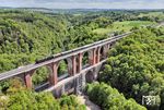 In früheren Jahren wurden Züge nur auf der unter der Elstertalbrücke bei Joketa durchführenden Strecke von Greiz nach Plauen (Vogtl) aufgenommen. Was sich auf dem markanten Bauwerk, über das die Bahnstrecke Leipzig–Hof führt, abspielte, blieb im Verborgenen, da die Brücke unzugänglich war. Heute ist die Brücke nochmehr im Dschungel verschwunden, also blieb für den Sonderzug mit 01 1104 nur das Drohnenfoto. (15.05.2025) <i>Foto: Joachim Schmidt</i>