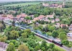 Durch Freckleben zwischen Sandersleben (Anhalt) und Aschersleben gelegen, führte schon seit dem frühen Mittelalter ein wichtiger Verkehrsweg am Ostrand des Harzes vorbei. Die Eisenbahn kam 'erst' 1865 hinzu. Von der Bedeutung des Ortes zeugt auch die oben rechts zu sehende Höhenburg, die um 900 entstand. 01 1104 fährt auf dem Weg nach Aschersleben (-Vienenburg) durch den Ort. (17.05.2025) <i>Foto: Joachim Schmidt</i>