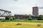 Das nächste Mal überquerte 01 1104 den Rhein über die Haus-Knipp-Brücke, einer Eisenbahnbrücke über den Rhein nördlich der Duisburg-Ruhrorter Häfen zwischen Duisburg-Beeckerwerth und Duisburg-Baerl im Verlauf der Güterzugstrecke Oberhausen-Osterfeld – Hohenbudberg. Das Gebäude (rechts) ist der ehemalige Förderturm von Schacht 8 der 1971 stillgelegten Zeche Rheinpreußen Schacht VIII. (21.05.2025) <i>Foto: Joachim Schmidt</i>