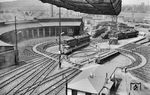 01 1001 auf der Drehscheibe im Bw Köln Bbf. Neben den Bahnbetriebswerken Altona und Ludwigshafen besaß nur das Bw Köln Betriebsbahnhof einen Doppel-Ringlokschuppen (dessen rechter Teil im Krieg zerstört wurde) mit zwei vorgelagerten Drehscheiben, deren Drehwege einander überschnitten. Da immer nur eine Drehscheibe bewegt werden konnte, reichte ein Drehscheibenwärter für die Bedienung aus. Gut zu erkennen ist auch die aufgeständerte Kohlenbahn, die die Lokomotivkohle wegen der beengten Platzverhältnisse im Bw von der Inneren Kanalstraße her zuführte. (14.07.1960) <i>Foto: Jacques H. Renaud</i>