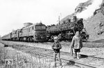Überholung im Bahnhof Samtschynzi durch 2M62-0410 vor einem Reisezug von Winnyzja nach Uman in der Zentralukraine. Gleichzeitig nutzt man den kürzesten Weg nach Hause, dann geht es auch schon mal direkt über das Gleis. (18.04.1997) <i>Foto: Ulrich Tack</i>