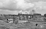 P36-0050 (Kolomna 10217/1955) führt einen Touristen-Sonderzug des Reiseveranstalters "Dsherelo" aus Kiew über den Slutsch-Viadukt bei Nowohrad-Wolynskyj (seit 2022 Swjahel) im Verlauf der Strecke Korosten—Schepetiwka in der Westukraine. Der Sonderzug besteht aus 5 regulären Schlafwagen, es folgen zwei Speisewagen, wobei der vordere als Bar- und Gesellschaftswagen fungiert. Am Zugschuß läuft der Personal-Schlafwagen. Die Lok wurde beim Depo Osipowitschi für Sonderfahrten vorgehalten und eigens für diese Fahrt von der Belarussischen Eisenbahn angemietet. (13.04.1997) <i>Foto: Ulrich Tack</i>
