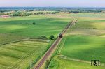 012 104 rollt zwischen Abelitz und Marienhafe durch die Weiten Ostfrieslands, dessen Küstenraum sich durch Marschland auszeichnet, das weiter landeinwärts in Niedermoore, Geest und Hochmoore übergeht. (31.05.2025) <i>Foto: Joachim Schmidt</i>