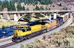 Auf der Ostrampe des Donnerpasses rollt ein Güterzug mit Autotransportwagen nach Reno hinunter. Die Wagen haben drei Ladedecks mit geschlossenem Aufbau. Als Vorspannlok ist Nr. 8615 der Chicago und Northwestern (Typ C44-9W Baujahr 1993), 2025 noch in Betrieb als Union Pacific Nr. 9679 am Zug. Es folgt Union Pacific Nr. 2441 (GE Typ C30-7, Baujahr 1979, ausgemustert am 30.04.1999) und Lok 9004 vom Lokmieter Motive Power Industries. Die EMD Typ SD45 war die ehemalige Southern Pacific Nr. 9015 (Baujahr 1969). Letztere ist 2025 noch unterwegs als Helm Leasing Nr. 9004. (22.08.1997) <i>Foto: Siegfried Graßmann</i>