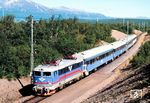 Lok 1188, eine Rc4 der SJ, fährt mit Reisezug 980 aus Luleå in den Haltepunkt Abisko Turiststation an der Bahnstrecke von Kiruna nach Narvik ein. Abisko liegt 195 km nördlich des Polarkreises nahe der schwedisch-norwegischen Grenze. Aufgrund seiner lokalen meteorologischen Besonderheiten, die dafür sorgen, dass der Ort ungewöhnlich viele klare Nächte aufweist, gilt Abisko als einer der am besten geeigneten Orte der Welt, um Polarlichter zu beobachten. (26.06.1999) <i>Foto: Siegfried Graßmann</i>