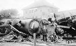 Am 31. Juli 1928 stießen im Bahnhof Dinkelscherben zwei Züge zusammen. Dabei kamen 23 Menschen ums Leben. Der in Richtung Augsburg fahrende Güterzug G 7535, beladen mit leeren Ölfässern, war am Unfalltag in ein Überholungsgleis gefahren worden, um dem nachfolgenden beschleunigten Personenzug BP 911 von Saarbrücken nach München die Durchfahrt durch den Bahnhof zu ermöglichen. In dem Personenzug reisten viele Urlauber in die Alpen. Der beschleunigte Personenzug, gezogen von der Augsburger 17 408, hielt fahrplanmäßig nicht in Dinkelscherben. Nach Einfahrt des Güterzuges in das Überholungsgleis versäumte es der Weichenwärter eine ordnungsgemäße Fahrwegprüfung durch Augenschein durchzuführen. Da wegen Bauarbeiten an diesem Tag auch die Signalabhängigkeit im Bahnhof aufgehoben war, fiel zudem das Versäumnis, die Einfahrweiche nicht wieder in Grundstellung gestellt zu haben, nicht auf. So kam es, dass, obwohl die Weiche nicht zurückgestellt war, der BP 911 am Einfahrsignal „Hp 1“ erhielt. Mit etwa 60–70 km/h näherte sich der Personenzug dem Bahnhof. Dessen Lokomotivführer erkannte noch die falsch gestellte Weiche und löste eine Schnellbremsung aus. Der Zug konnte aber nicht mehr zum Halten gebracht werden, gegen 16.00 Uhr fuhr er auf das Ende des Güterzugs auf. Da der Personenzug überwiegend aus Wagen mit Holzaufbau bestand, die zertrümmert wurden, kam es in der Folge zu den vielen Toten und 51 Verletzten. Die Lokomotive kippte zur Seite. (01.08.1928) <i>Foto: RBD Augsburg</i>
