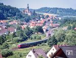 V 200 002 auf der Rückfahrt von Neuenmarkt-Wirsberg nach Bayreuth in Trebgast. Am Hausbahnsteig kreuzt ein 798. Auf der Anhöhe steht die evangelische Pfarrkirche St. Johannes. Das denkmalgeschützte Bauwerk entstand Mitte des 18. Jahrhunderts. (03.07.1985) <i>Foto: Joachim Schmidt</i>