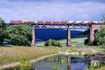 Eine 140 im neuen orientroten Farbkleid (RAL 3031) vor einem Sgk auf der Werrabrücke bei Oberrieden. (30.05.1990) <i>Foto: Wolfgang Bügel</i>