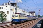 Die Kölner 110 257 fährt mit N 8724 nach Neuss durch den S-Bahn-Haltepunkt Düsseldorf Völklinger Straße. Die Fa. Liesegang war ein auf Tageslichtprojektoren und Multimediaprojektoren spezialisiertes Unternehmen und galt als ein deutscher Traditionshersteller von Projektionstechnik. 2004 ging die Firma in Insolvenz. Das analoge Zeitalter war vorbei. (26.06.1990) <i>Foto: Wolfgang Bügel</i>
