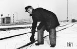 Der Hemmschuhleger ist für das Aufhalten ablaufender Eisenbahnwagen mittels Hemmschuhen zuständig. Dabei legt er den Hemmschuh auf eine der beiden Schienen auf, um so einen ablaufenden Wagen vor im Gleis stehenden Wagen oder einem anderen Hindernis aufzuhalten.  (1961) <i>Foto: BD Essen</i>